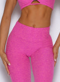 zoomed in front view of a model highlighting the straight waistband wearing the Curvemax leggings in neon pink sorbet color