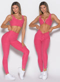 front profile view of a model wearing the Curvemax leggings in petal kiss color showcasing the adjusted and non adjusted version of the waistband side by side