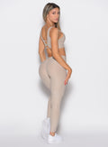 back right side profile view of a model looking over her shoulder wearing the Curvemax leggings in Taupe color