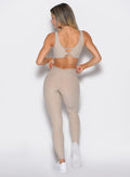 back profile view of a model facing to the left side wearing the Curvemax leggings in Taupe color