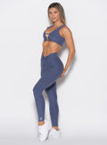 front left side profile view of a model wearing the Curvemax leggings in wisteria blue color 