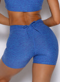 zoomed in back profile view of a model wearing the Curvemax shorts in neon blue rave color