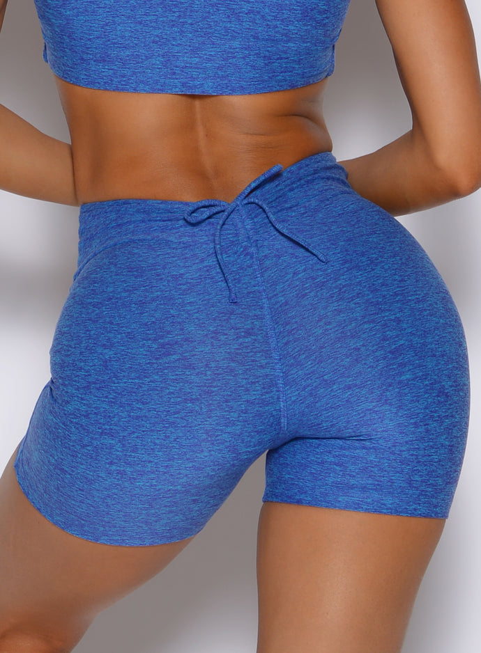 zoomed in back profile view of a model wearing the Curvemax shorts in neon blue rave color