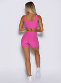 back side profile view of a model wearing the Curvemax shorts in neon pink sorbet color
