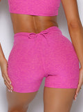 close up back profile shot of a model wearing the Curvemax shorts in neon pink sorbet color