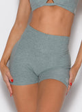 close up front profile view of a model with both hands on her thighs wearing the Curvemax Shorts in sea moss color