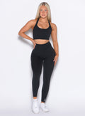 front profile view of our model with one hand on her waist wearing the Curves Leggings in Black color
