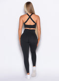 Back profile view of our model wearing the Curves Leggings in Black color paired with the matching top. 