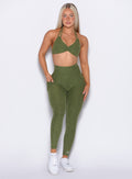 front profile view of our model with one hand inside the pocket of the leggings wearing the Curves 2.0 Leggings in Juniper color