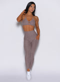 front profile view of a model wearing our curves leggings in london fog color along with the matching bra 