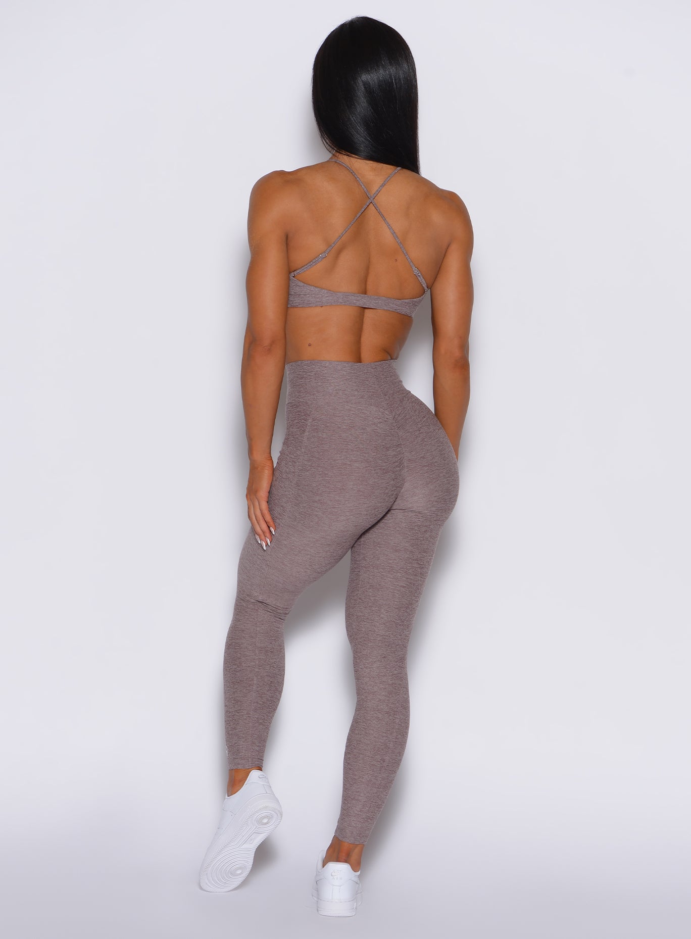 Back profile view of a model wearing our curves leggings in london fog color along with the matching bra