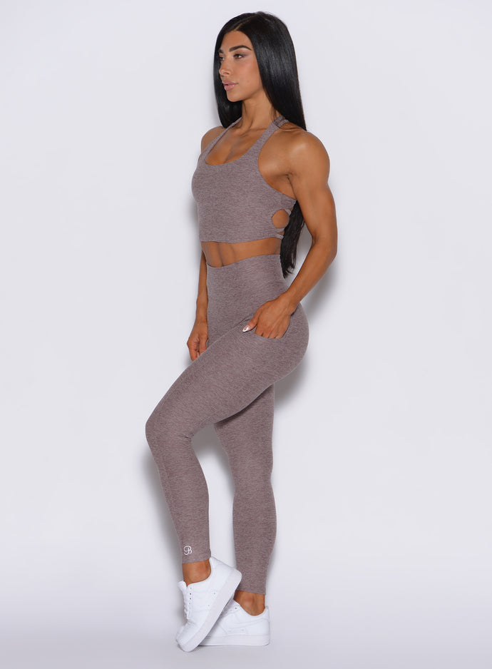 left side profile view of a model wearing our curves leggings in london fog color along with the matching bra