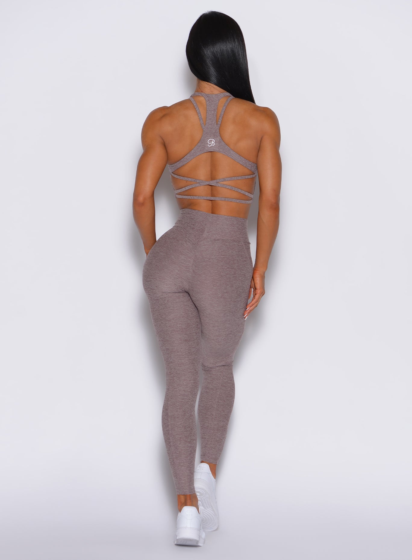 back profile view of a model wearing our curves leggings in london fogh color along with the matching sports bra