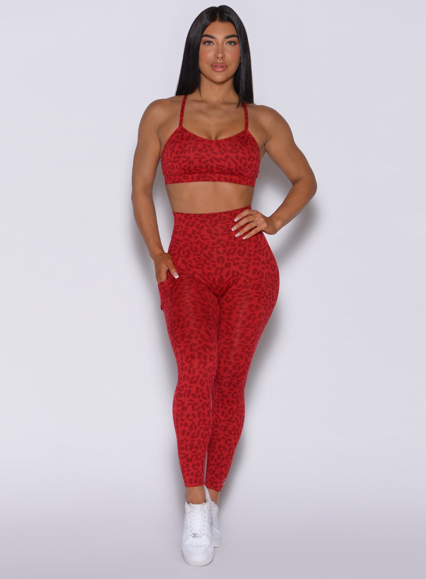 Front profile view of a model in our curves leggings in red cheetah color and a matching sports bra 