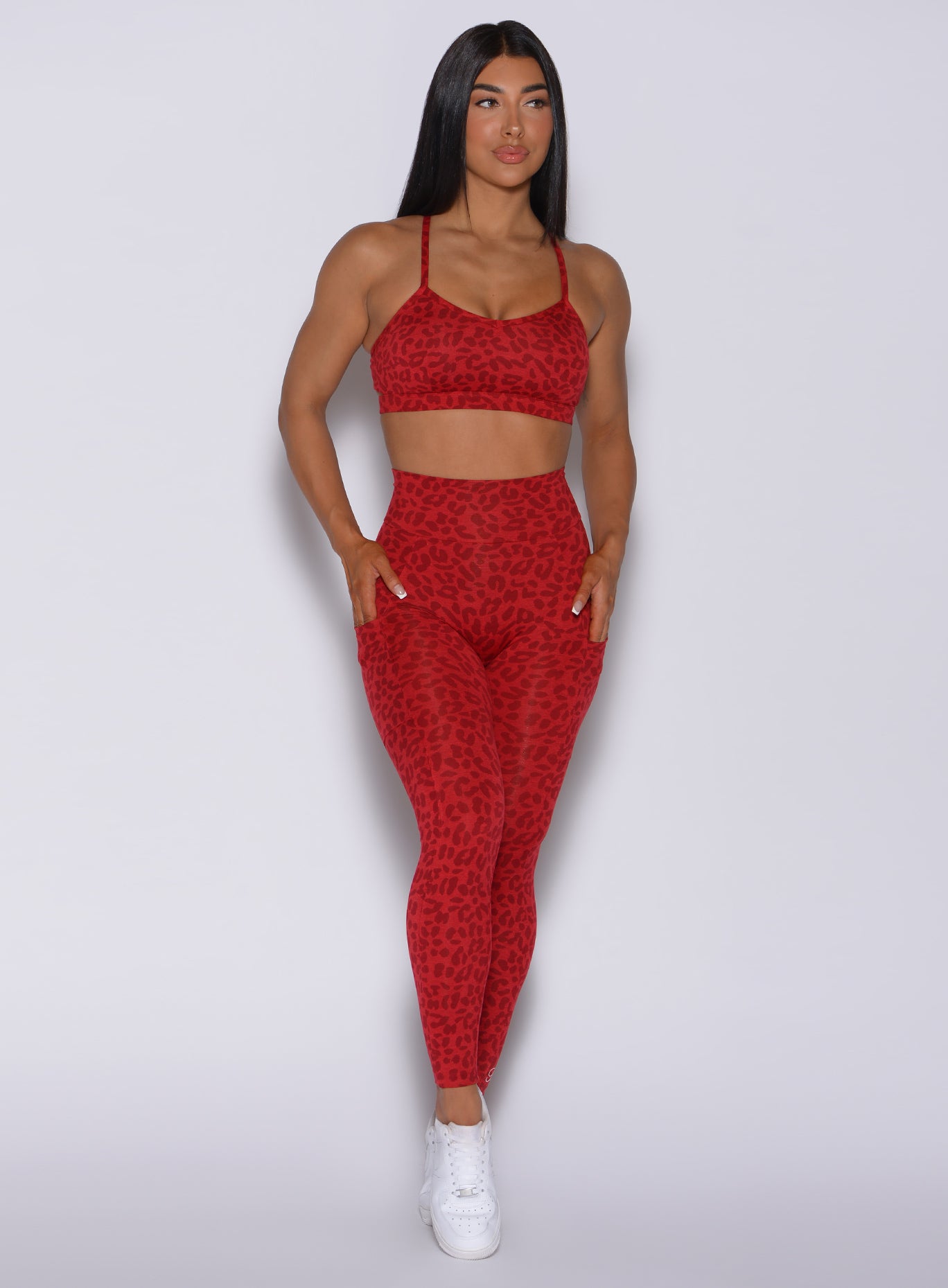 Front profile view of a model wearing our curves leggings in red cheetah color and a matching bombshell sports bra