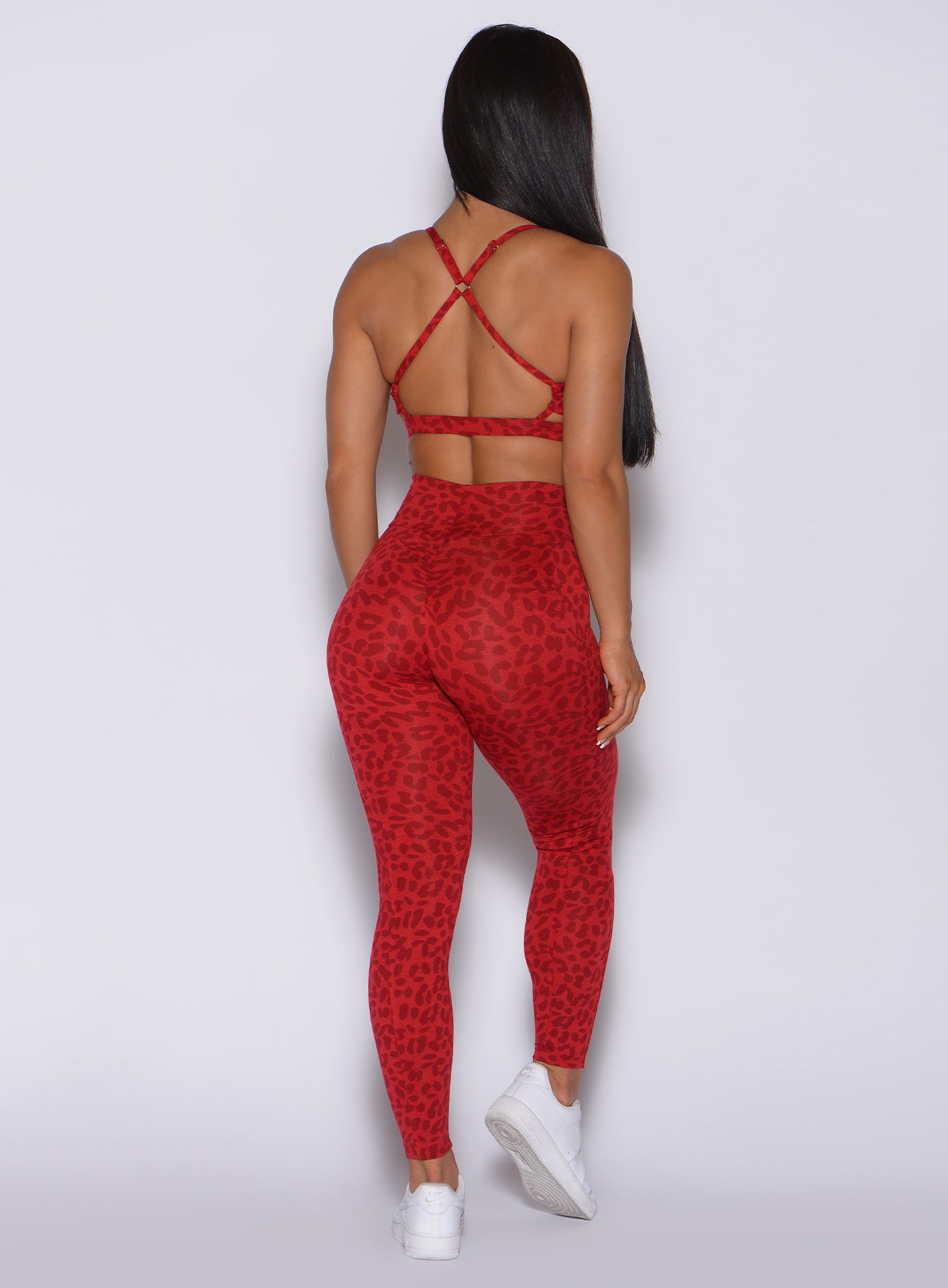 Back profile view of a model in our curves leggings in red cheetah color and a matching bra