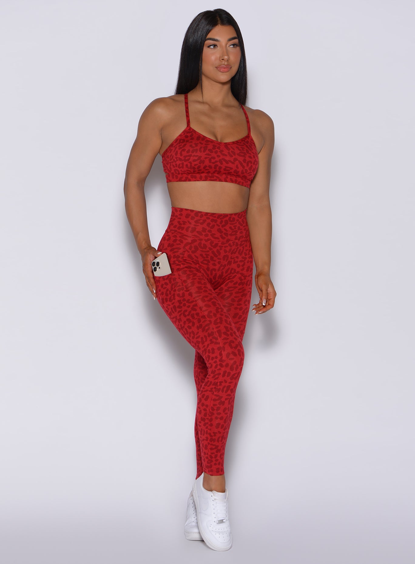 Front profile view of a model in our curves leggings in red cheetah color and a matching bombshell bra