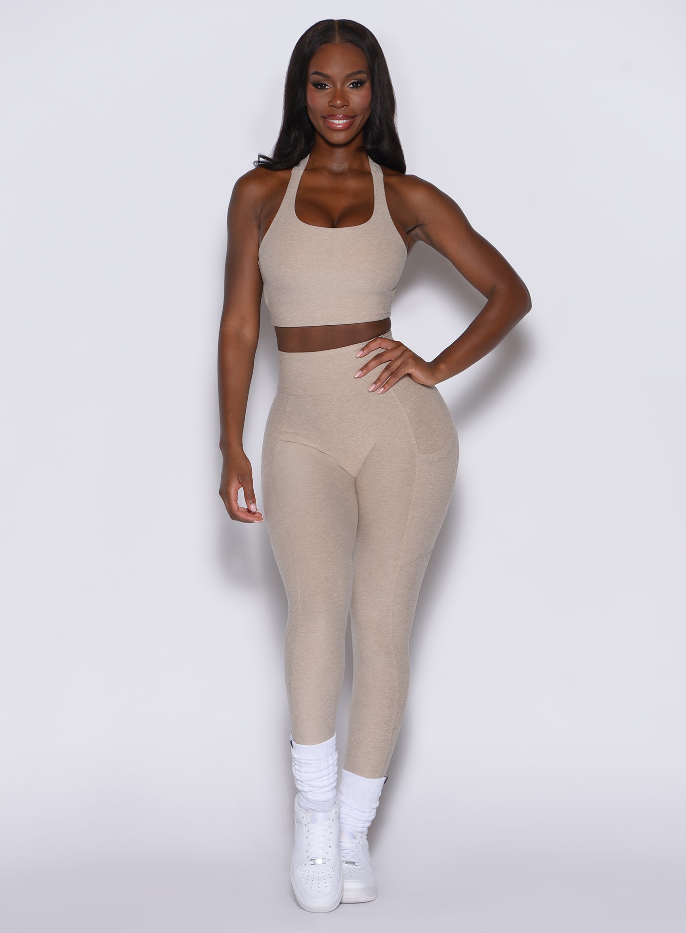 front profile view of a model wearing our Curves leggings in taupe color along with the matching sports bra.
