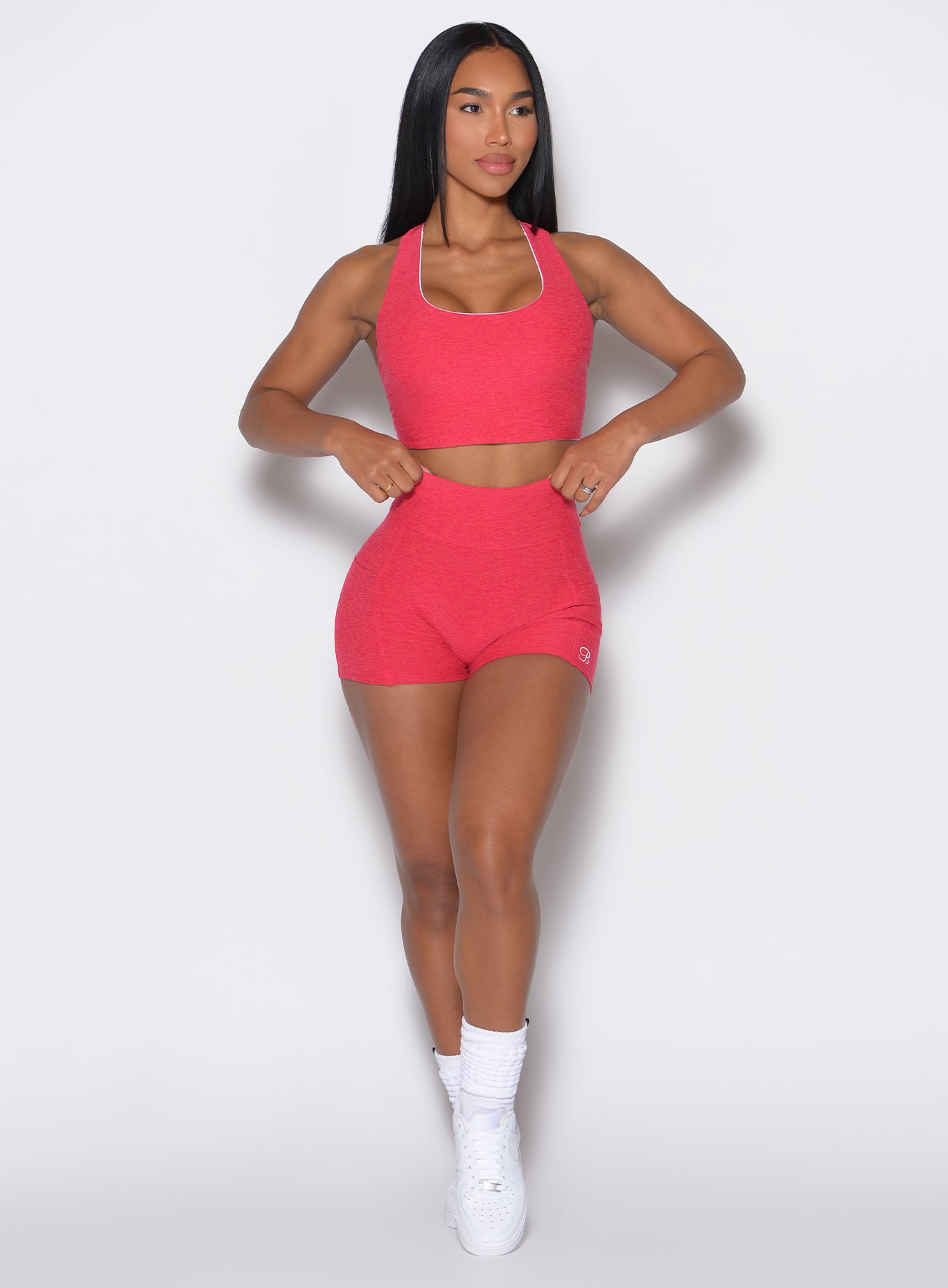 model facing forward wearing our scrunch shorts in raspberry punch color along with a matching top 