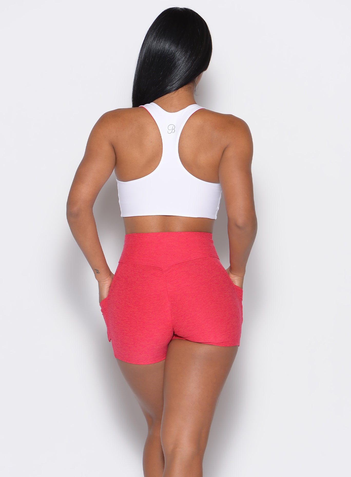 back profile view of a model wearing a reversible tank bra in white color along with a matching shorts