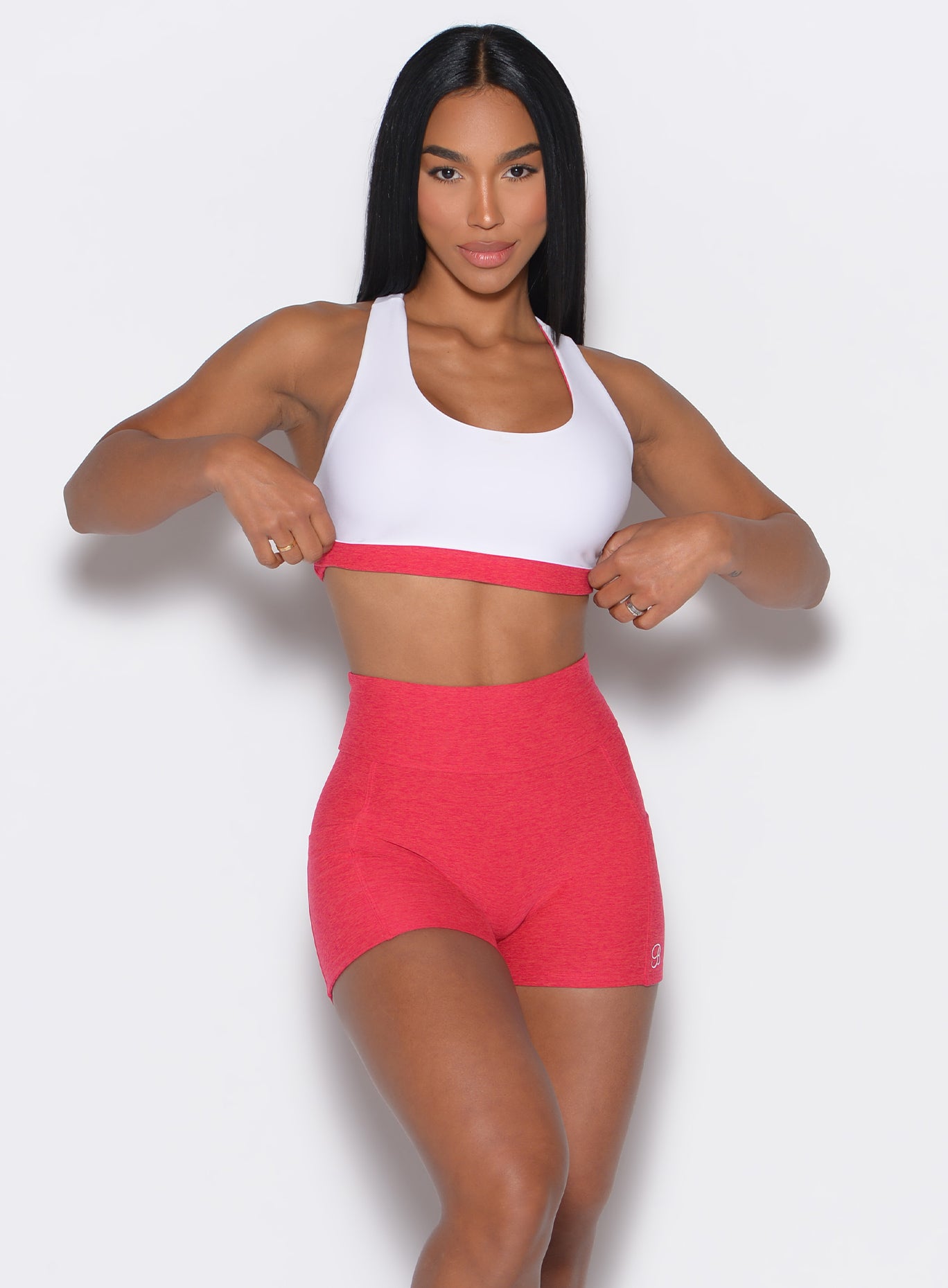 front profile view of a model facing forward wearing a reversible tank bra in raspberry punch color along with a matching shorts
