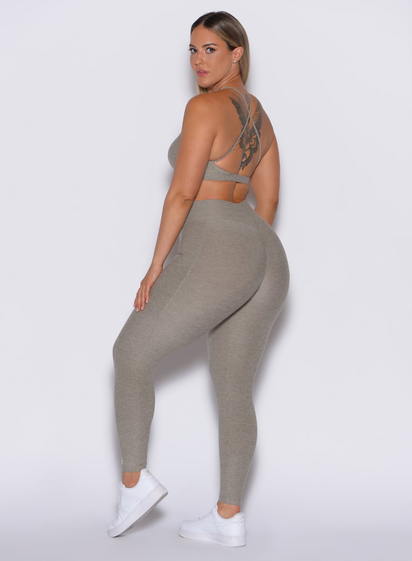 left side profile view of a model wearing our curves leggings in nori color along with the matching bra