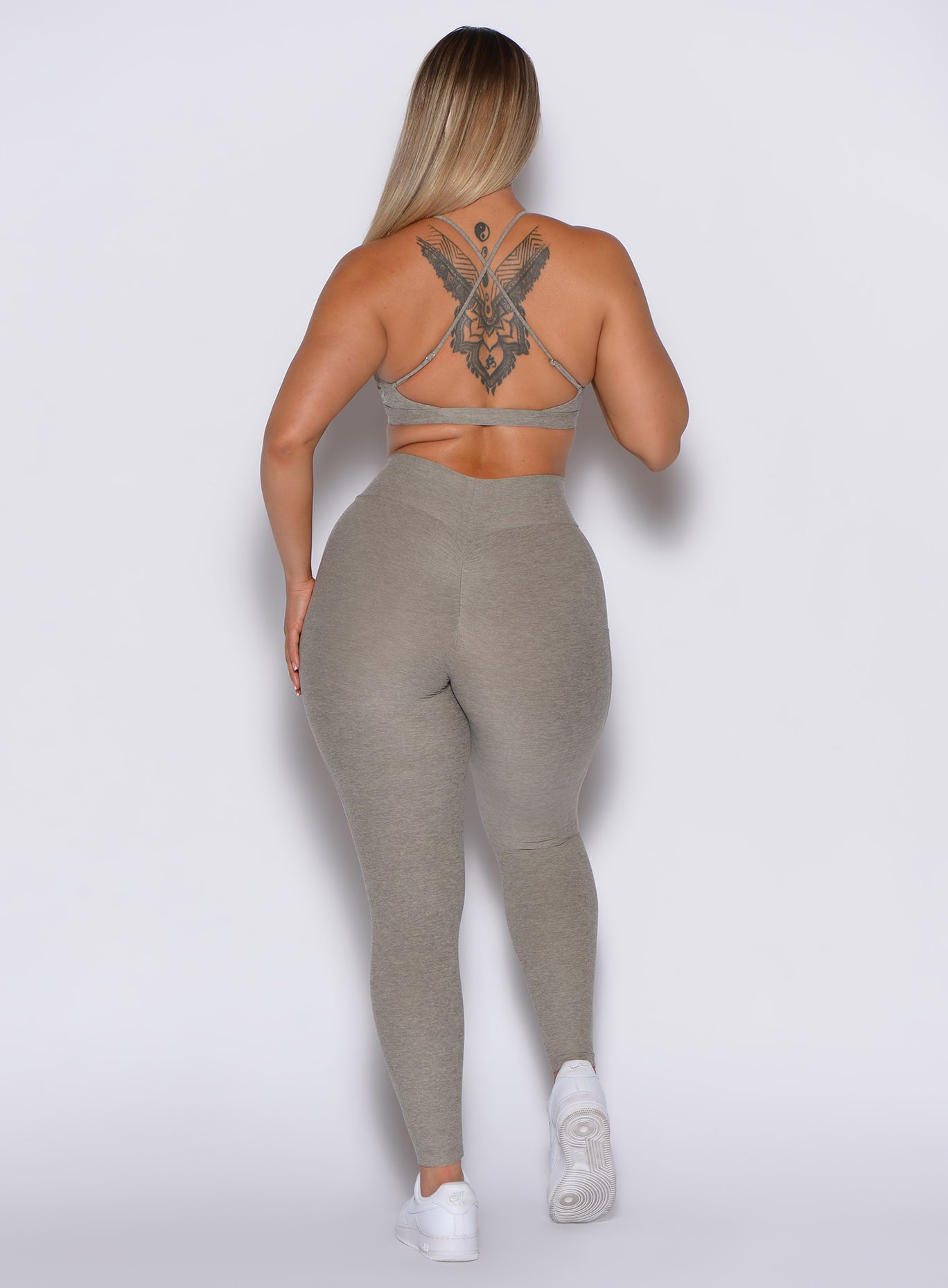 back profile view of a model in our curves leggings in nori color along with the matching bra