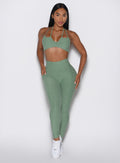 front profile view of a model wearing the Define Leggings in basil color paired with the matching bra