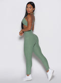 side profile view of a model wearing the Define Leggings in basil color paired with the matching bra
