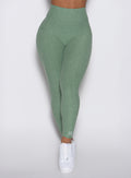 close up front view of a model wearing the Define Leggings in basil color