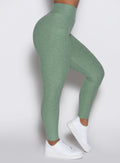 close up right side profile view of a model wearing the Define Leggings in basil color