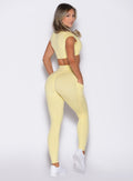 back right side profile view of a model wearing the Define Leggings in Soft Yellow color
