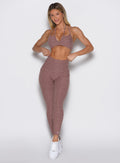 front profile view of a model wearing the Define Leggings in walnut color paired with the matching bra