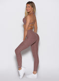 left side profile view of a model wearing the Define Leggings in walnut color