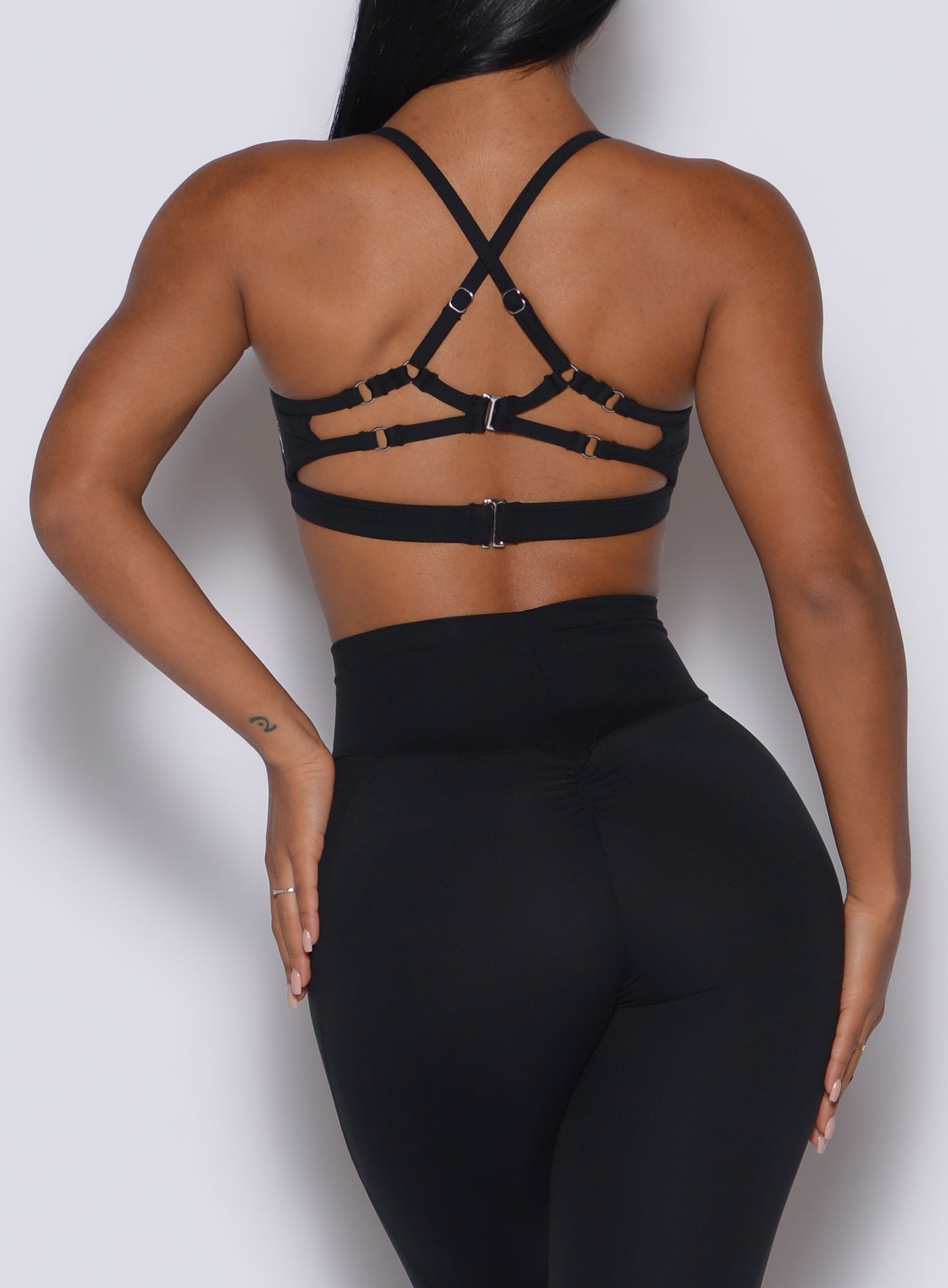 Back profile view of a model in our black Diamond sports bra and a matching leggings 