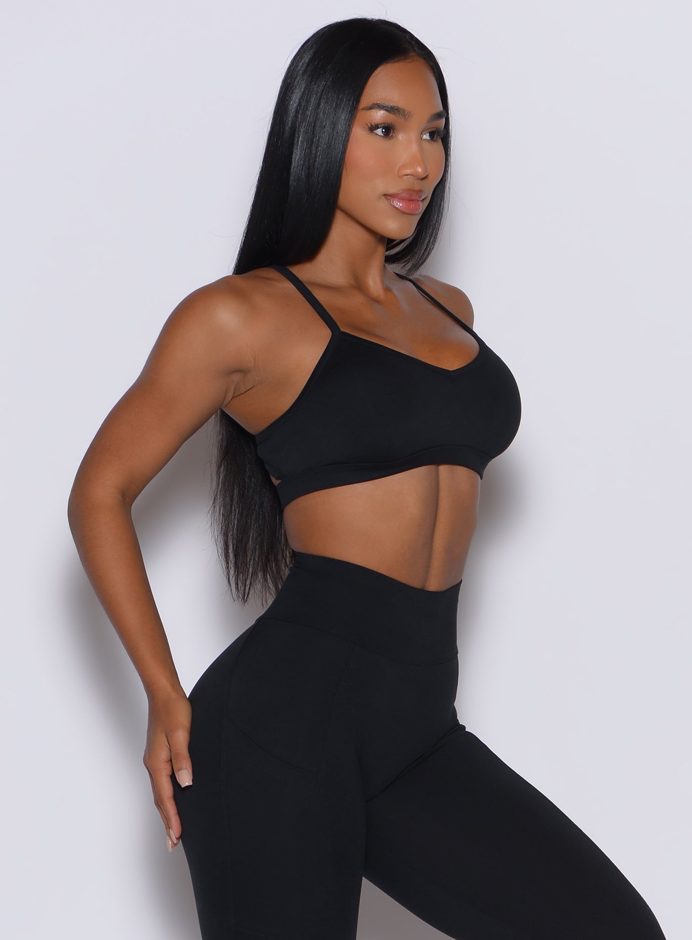Right side profile of a model wearing our black diamond sports bra and a matching leggings