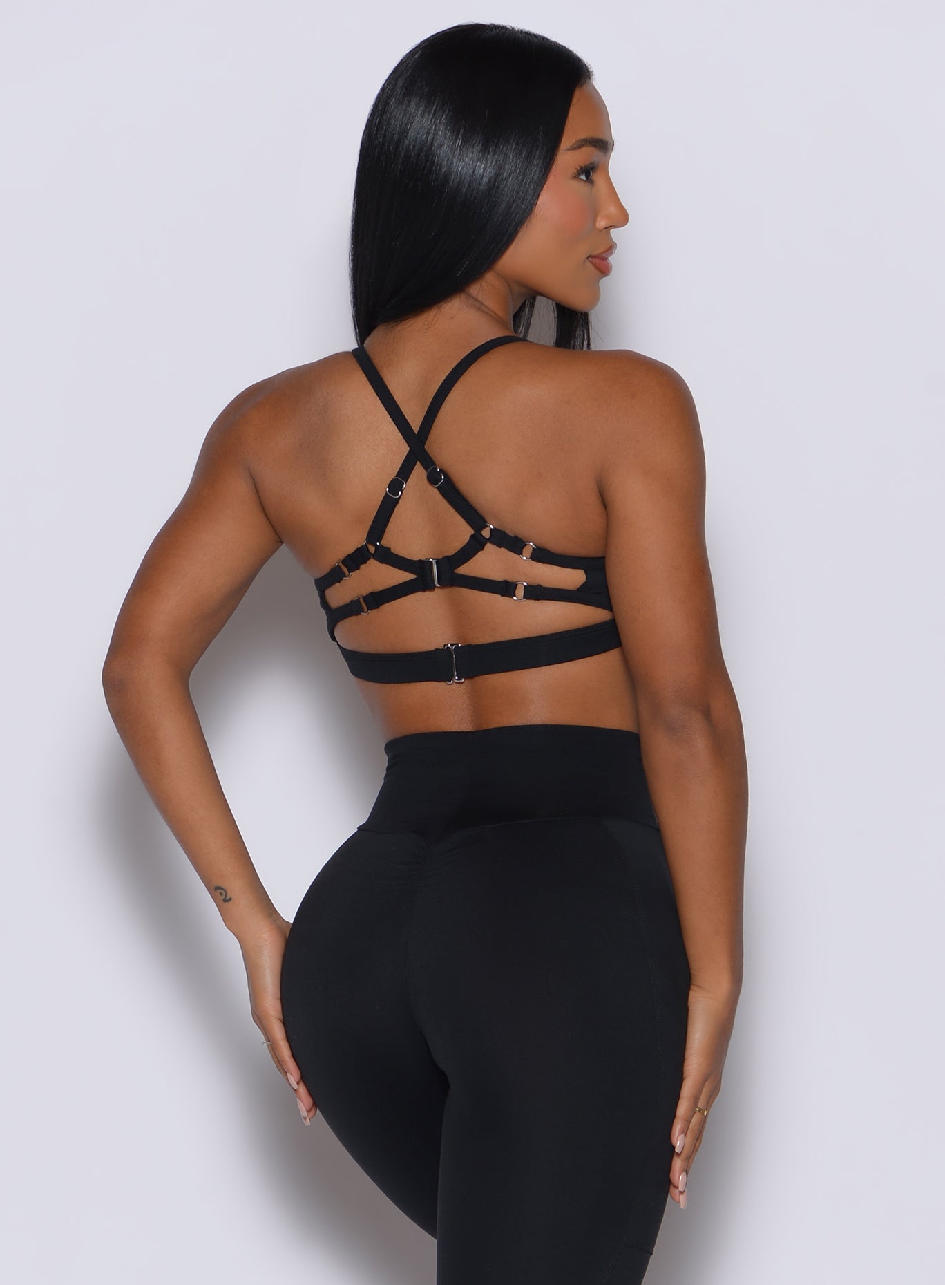 Back profile of a model wearing our black diamond sports bra and a matching leggings