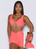picture showcasing the two way style the Dualmode Bra in neon apricot pink color can be worn while highlighting the B logo in front