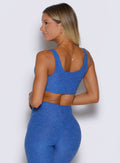 back shot of a model wearing the Dualmode Bra in Neon Blue rave color