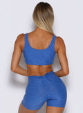 back profile view of a model wearing the Dualmode Bra in neon blue rave color 