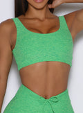 front profile view of a model wearing the Dualmode Bra in neon miami beach color without the B logo in front