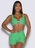 frontal view of a model with one hand on her waist wearing the Dualmode Bra in Neon Miami Beach color