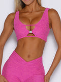 front profile view of a model with the B logo hardware in front wearing the Dualmode Bra in neon pink sorbet color 