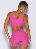 back profile view of a model wearing the Dualmode Bra in neon pink sorbet color 