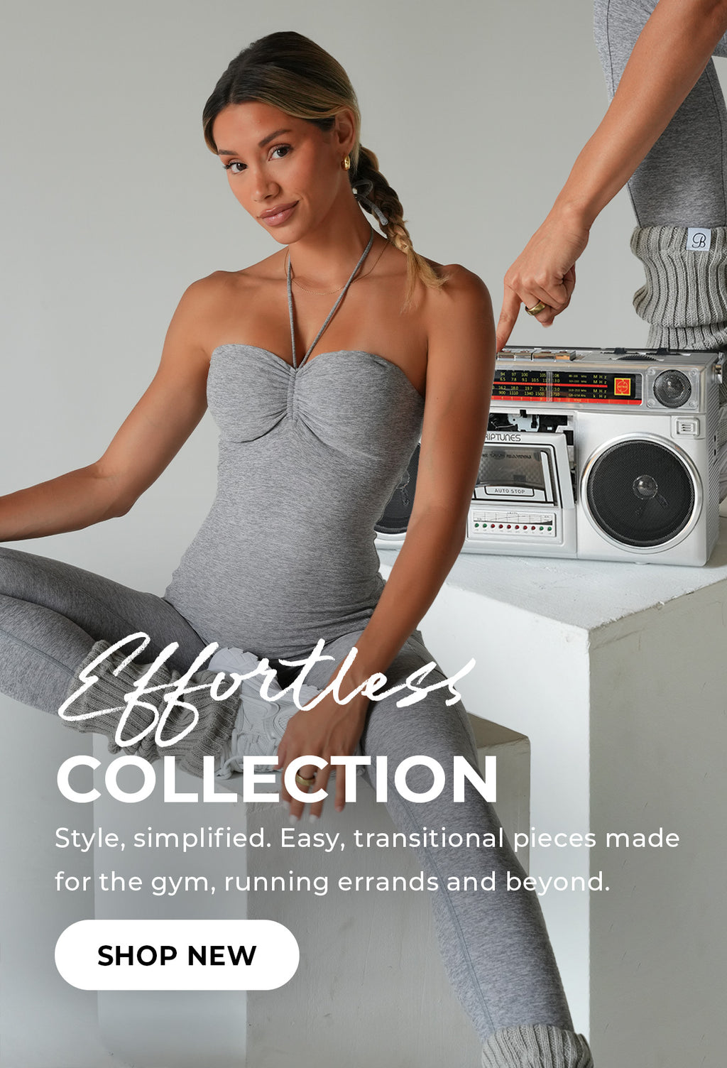 "Effortless Collection" banner with a model in a grey halter bodysuit and leggings, sitting beside a vintage boombox. Bold text: "Effortless Collection." Subtext reads "Style, simplified. Easy, transitional pieces made for the gym, running errands and beyond." CTA button reads "Shop New."