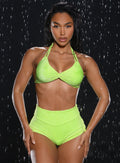 front profile view of a model with water droplets falling around her wearing the Sunkissed Sparkle Bikini Top in Electric Lime color