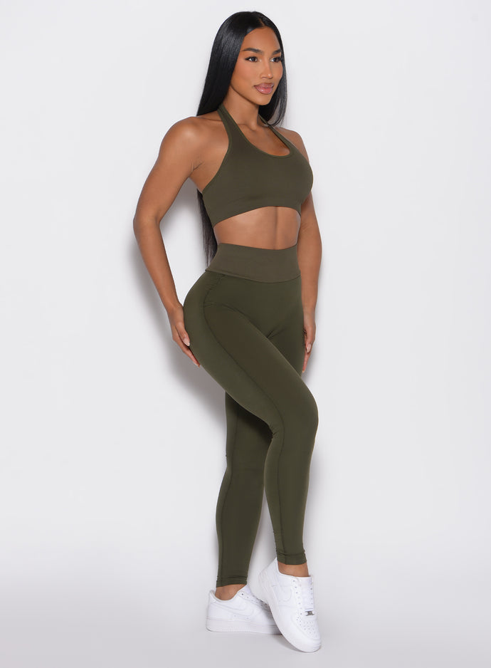 front right side profile view of a model wearing the Figure Butt Lift Leggings in forest night color