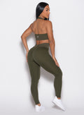 back right side profile view of a model wearing the Figure Butt Lift Leggings in forest night color
