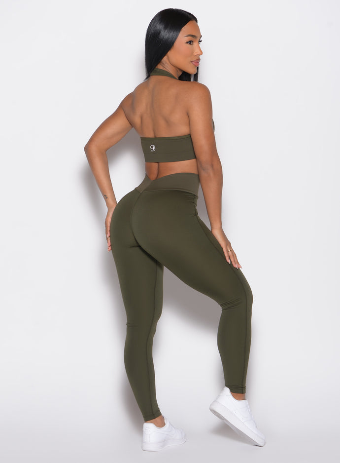 back right side profile view of a model wearing the Figure Butt Lift Leggings in forest night color