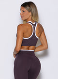 back profile view of a model facing to the left wearing the Finish Line Tank in black orchid color
